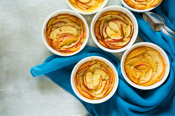 Portioned apple cobbler in white bowls on grey metal background. Top view
