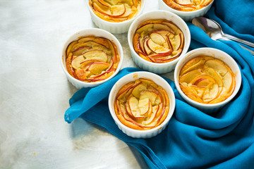 Portioned apple cobbler in white bowls on grey metal background. Top view
