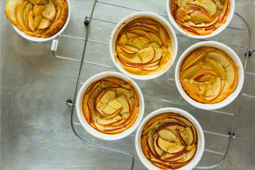 Portioned apple cobbler in white bowls on grey metal background. Top view