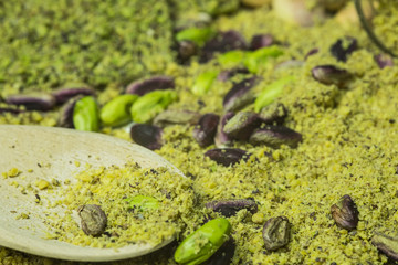 Green pistachio cookie of Bronte with wooden spoon and glasses