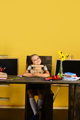 Girl sits at desk with colorful stationery, flowers and fruit