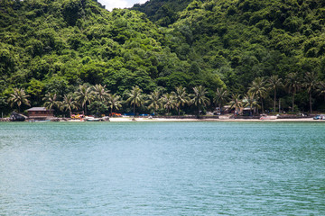cruising among beautiful limestone rocks and secluded beaches in Ha Long bay, UNESCO world heritage site, Vietnam