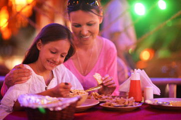 mother and daughter eating in cafe