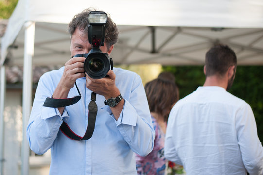 A wedding photographer takes pictures in action