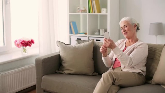 old woman with smartphone having video chat