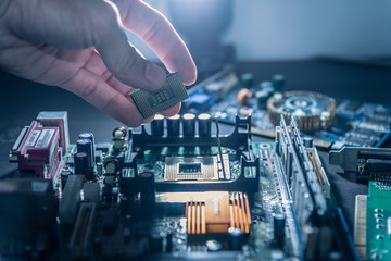 The technician is putting the CPU on the socket of the computer motherboard.