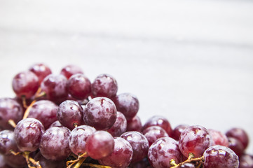 Bunches of fresh ripe red grapes on a marble table. Close up. Selective focus