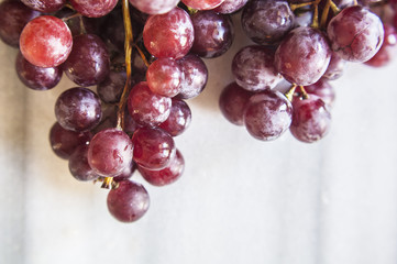 Bunches of fresh ripe red grapes on a marble table. Close up. Selective focus