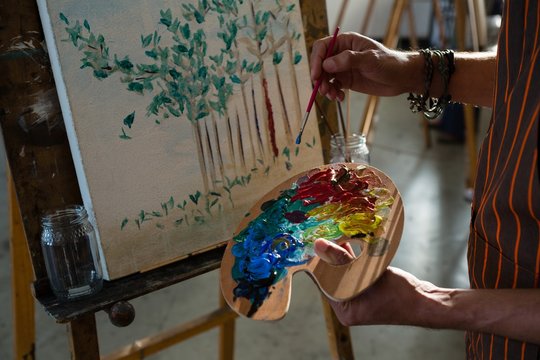 Cropped image of artist paining on canvas