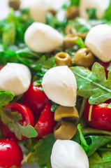 Fresh salad with tomatoes, green olives and mozzarella. Selective focus, close up