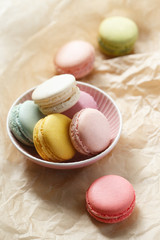 Colorful macarons on a brown background. French sweets assortment viewed from above on a neutral paper background