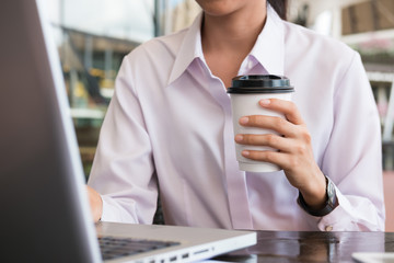 businesswoman with laptop computer sitting outside office building. young asian woman analyzing investment charts outdoors. business people with is late for work