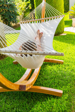 Girl relaxing and listening to music in hammock