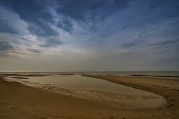 Fototapeta na wymiar beach when sea dry and rainy cloud sky
