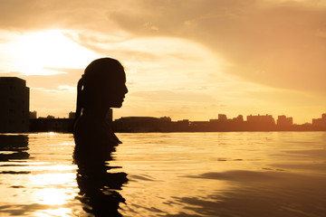 Naklejka na ściany i meble silhouette of girl swimming in the pool