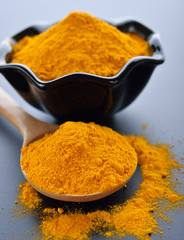Turmeric powder on black background.