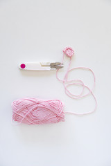 set of pink wool and needle for creating baby clothes