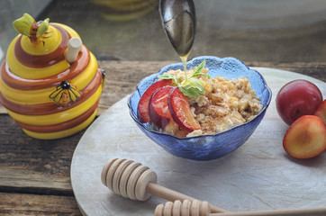 Breakfast of oatmeal from ripe red plums