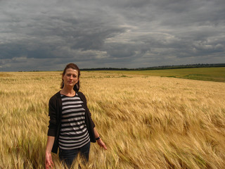 Naklejka na ściany i meble Girl on a field of wheat