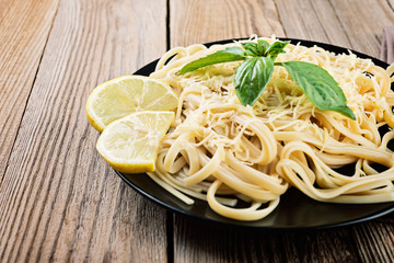 Italian spaghetti   with  cheese and fresh basil - homemade healthy italian pasta on rustic wooden background.