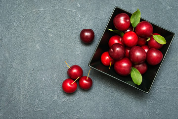 fresh plums in black plate on dark  background