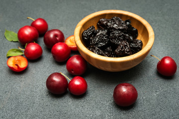 Prunes, dried plums in wooden bowl on dark  background