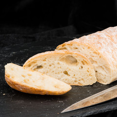 selective focus on fresh sliced warm homemade bread on dark background