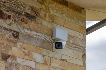white CCTV camera on a stone wall