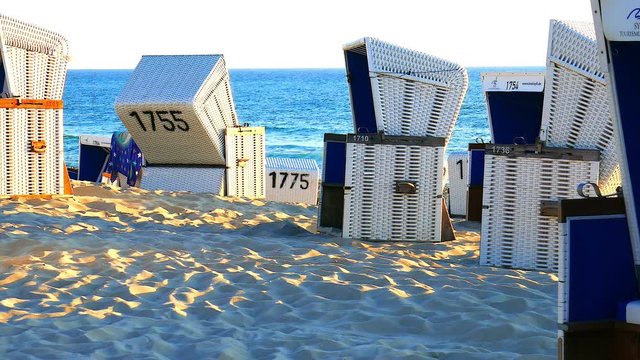 Weisse Strandk&ouml;rbe vor ruhiger Nord See im warmen Sonnenuntergang Licht