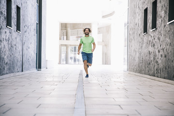 Young man running on the street in urban environment