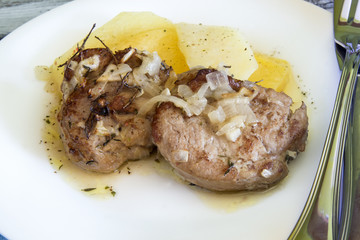 Pork tenderloin with french fries served on a plate