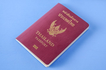 Thailand passport  brown cover  on blue paper background for traveling on holidays