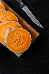 pieces of fresh raw pumpkin on a black background