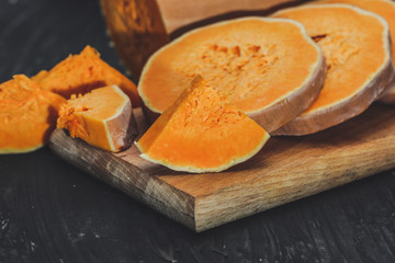 pieces of fresh raw pumpkin on a black background