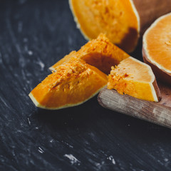 pieces of fresh raw pumpkin on a black background