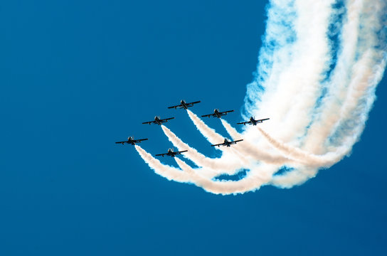 Fighter flies in the smoke in the blue sky aerobatics