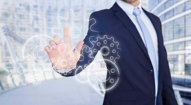 Businessman touching technology interface with gear wheel setting
