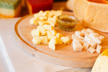 Cheese platter, parmesan on natural wood plate with sauce