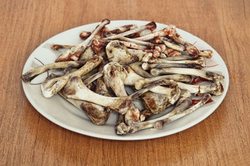 Heap of picked chicken bones on plate taken closeup.Poverty concept.