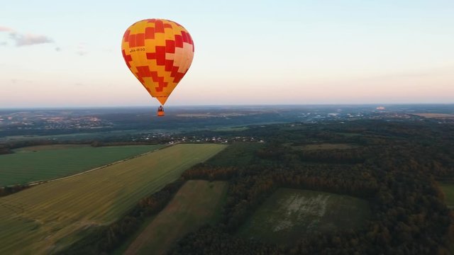 Aerial view Hot air balloon in the sky over a field in the countryside in the beautiful sky and sunset. Aerostat fly in the countryside. Aerial footage, 4K
