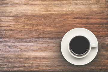 Coffee cup top view on wooden table background.