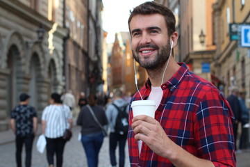 Handsome man holding disposable coffee cup outdoors