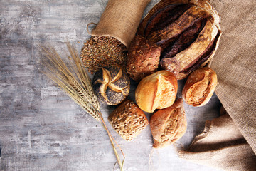 Different kinds of bread and bread rolls on board. Kitchen or bakery poster design.