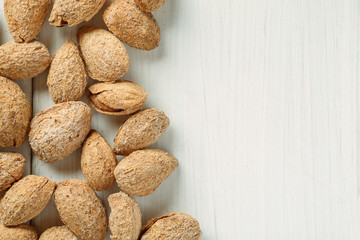 Almond in shell on a white table, top view, copy space