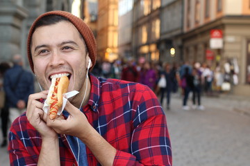 Ethnic male devouring a hot dog