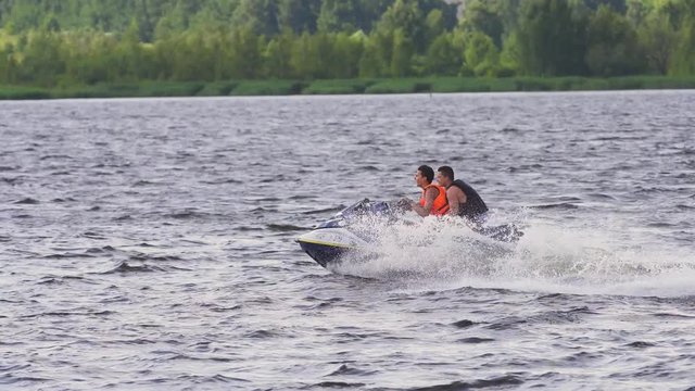 People riding on a jet ski. High speed jetski with water spray. People rid on water scooter. 4k.