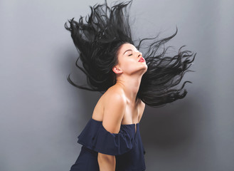 Young woman with floating hair on a solid background