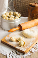 Traditional pelmeni or dumpling at cutting board. Homemade preparation food.