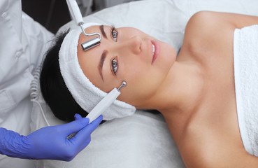 The cosmetologist makes the apparatus a procedure of Microcurrent therapy of a beautiful, young...