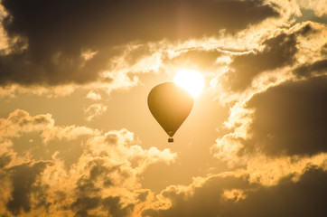 Fototapeta premium The balloon flies against the background of the sun
